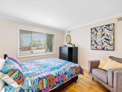 a bedroom with a bed and a couch and a window at Thurlow Avenue 49 Unit 1 in Nelson Bay