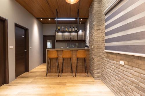 a kitchen with bar stools and a brick wall at 探尋旅者Homestay in Magong