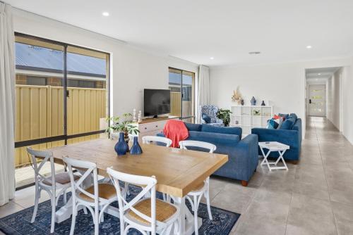 a living room with a table and a blue couch at Meadows in Dunsborough