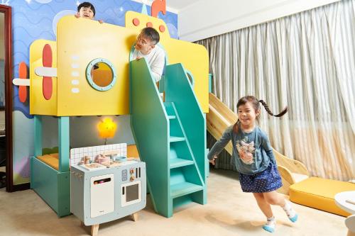 a child playing in a bunk bed in a room at The Howard Plaza Hotel Taipei in Taipei