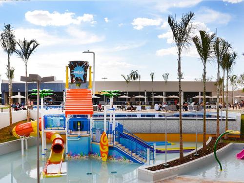 a playground in a water park with a clock tower at Resort Olimpia Apartamento in Olímpia