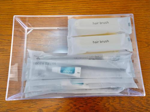 a plastic container filled with toothbrushes and toothpaste at West Villa in Naha