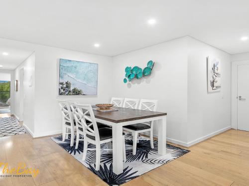 a white dining room with a table and chairs at Karavostazi at The Shoal in Shoal Bay