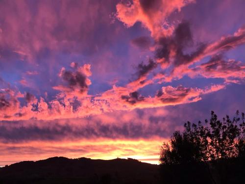a sunset with purple and orange clouds in the sky at Maungatautari Outlook Cambridge in Cambridge