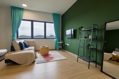 a living room with green walls and a couch at Encorp Strand Residences by Airhost in Kota Damansara