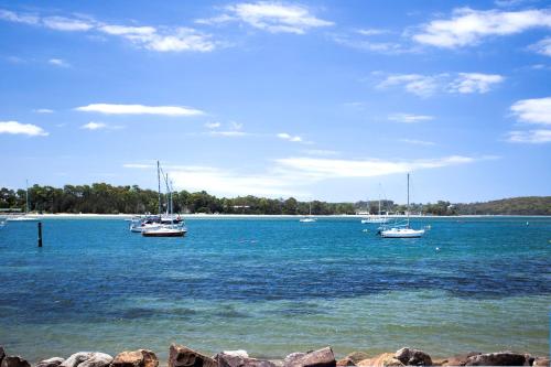 a group of boats floating on a large body of water at Bay Breeze Boutique Accommodation in Batemans Bay