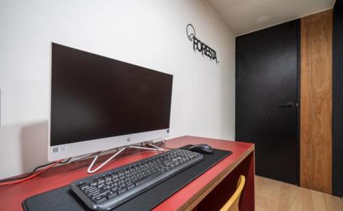 a computer monitor and a keyboard and mouse on a desk at HOTEL701 Masan in Changwon