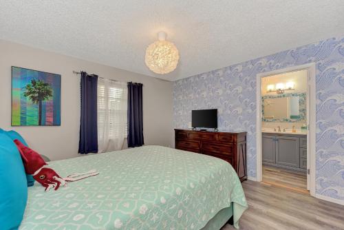 a bedroom with a bed and a dresser and a tv at Pink Flamingo Unit, Steps to Beach, Siesta Key Village & Pet-Friendly in Siesta Key