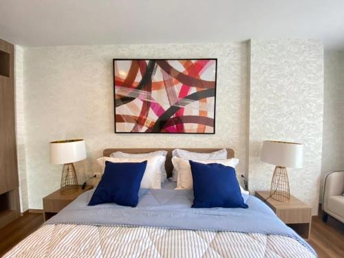 - une chambre avec un lit doté d'oreillers bleus et d'un tableau dans l'établissement LA HABANA501, à Hua Hin