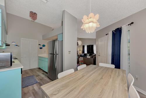 a kitchen and dining room with a table and a refrigerator at Jellyfish-Flamingo House, Amazing Location On Beach & Walk To Village in Siesta Key