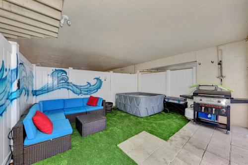 a living room with a blue couch and a grill at Jellyfish-Flamingo House, Amazing Location On Beach & Walk To Village in Siesta Key
