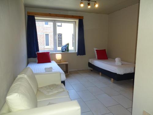 ein Wohnzimmer mit 2 Betten und einem Sofa in der Unterkunft Condo Gardens Leuven - Budget Studio Twin in Löwen