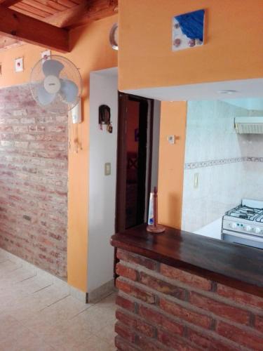 a kitchen with a counter and a brick wall at Rinconada 2 in Las Grutas
