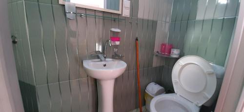 a small bathroom with a toilet and a sink at Guesthouse Next to beach in Batumi