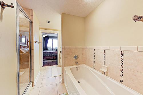 een badkamer met een bad en een douche bij Grand Panama Tower II in Panama City Beach