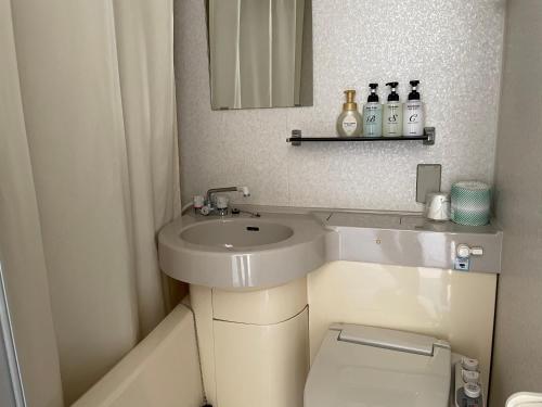 a bathroom with a sink and a toilet and a mirror at 湘南リリーフ in Yokosuka