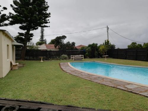 a swimming pool in the yard of a house at Rockview Holiday Beach Apartment in Hibberdene