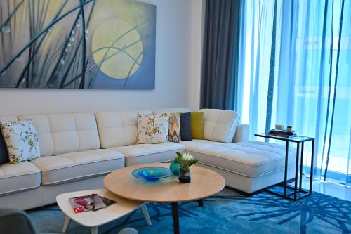 a living room with a white couch and a table at Springfield Suites in Seef