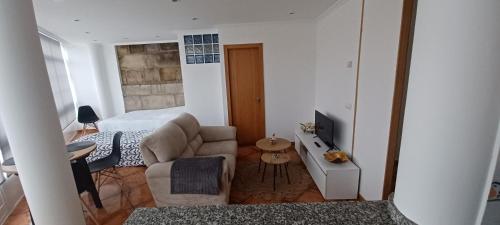 1 dormitorio con cama, sofá y TV en Loft Turístico, en Vigo