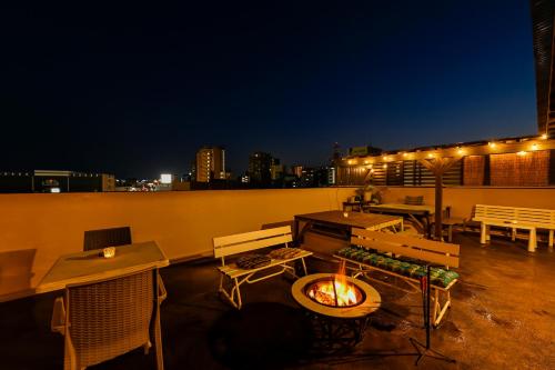 a patio with a fire pit on a rooftop at night at Green Guesthouse in Kagoshima