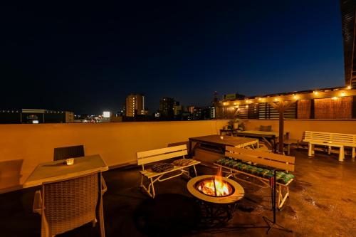 un patio con una hoguera en la azotea por la noche en Green Guesthouse, en Kagoshima