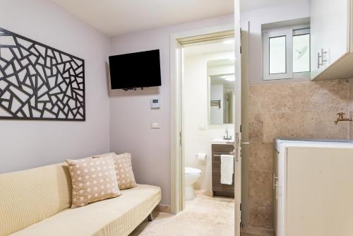 a living room with a couch and a tv on the wall at Mareazul Beach Front Condos At playa del Carmen in Playa del Carmen
