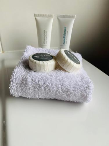 two toothbrushes and two cups on a towel at Airlie Beach Apartments in Airlie Beach