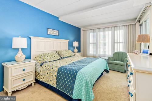 a blue bedroom with a bed and a chair at Sandpiper Dunes II in Ocean City