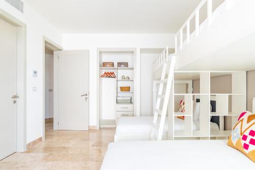 a bedroom with white furniture and a white staircase at Mareazul Beach Front Condos At playa del Carmen in Playa del Carmen