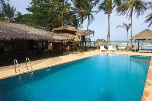 a large blue swimming pool next to a beach at Moonwalk Lanta Resort in Ko Lanta