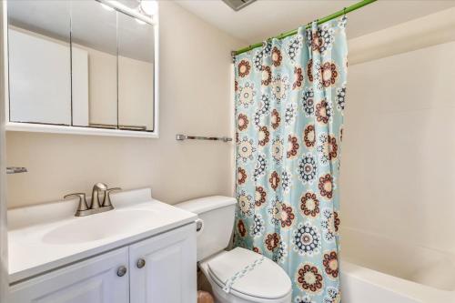 a bathroom with a toilet sink and a shower curtain at Sea Watch Condos III in Ocean City