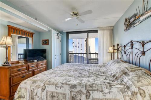a bedroom with a bed and a television and a window at Sea Watch Condos IX in Ocean City