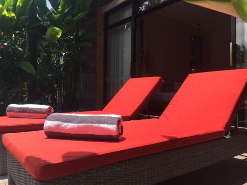 two red chairs sitting on top of a table at Le Chien Rouge in Lovina