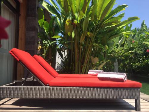a red wicker chair sitting on a patio at Le Chien Rouge in Lovina