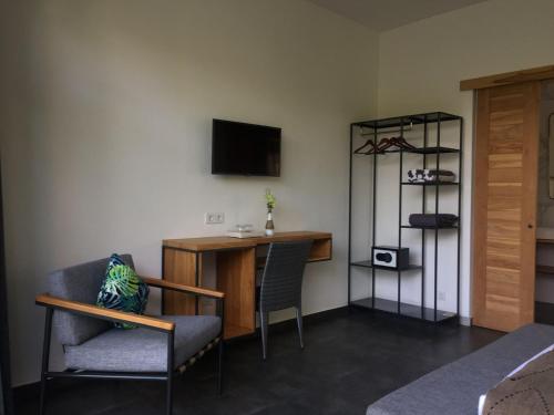 a room with a desk and a chair and a tv at Le Chien Rouge in Lovina