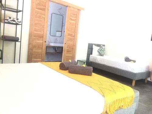 a bedroom with a bed with a yellow blanket on it at Le Chien Rouge in Lovina