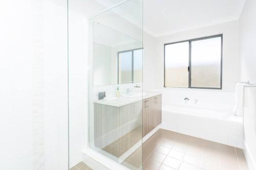 a white bathroom with a shower and a sink at The Kingsley’s Place - EXECUTIVE ESCAPES in Perth