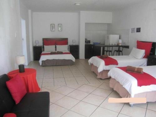 a large room with two beds and a couch at Airport Leisure Lodge in Kempton Park