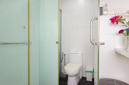 a bathroom with a toilet and a glass shower door at Encorp Strand Residences by Airhost in Kota Damansara