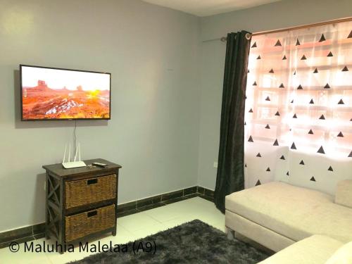 a living room with a tv on a wall at Maluhia Halelaa- A9 in Naivasha