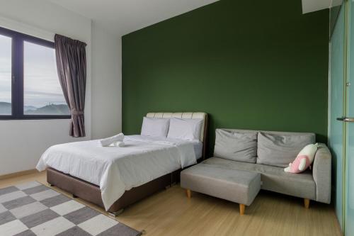 a green bedroom with a bed and a couch at Encorp Strand Residences by Airhost in Kota Damansara