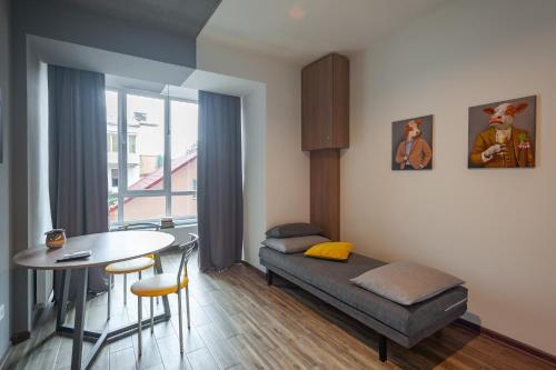 un soggiorno con un letto e un tavolo di Like Home on IN a Ivano-Frankivsʼk