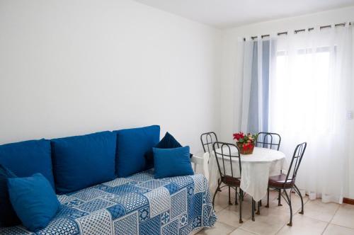 uma sala de estar com um sofá azul e uma mesa em Apartamento aconchegante em Petrópolis