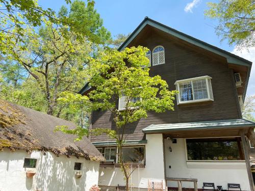 una casa grande con techo de gambrel en Pension Razteca, en Hakuba