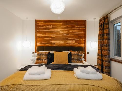 a bedroom with a large bed with two towels at Orchard View Lodge in Exeter