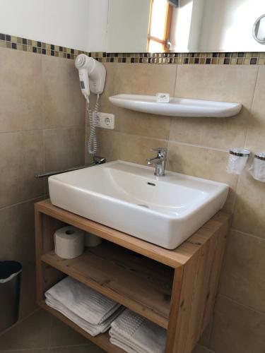 a bathroom with a sink and a phone on a shelf at Haus Annabelle in Wagrain