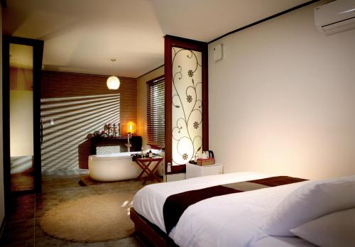 Thai Story في سيوجويبو: غرفة نوم فيها سرير وحوض استحمام