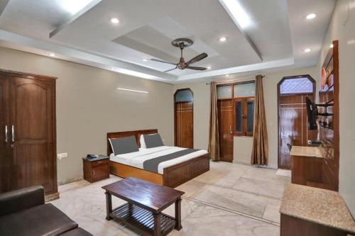 a bedroom with a bed and a ceiling fan at HOTEL OM PLAZA in New Delhi