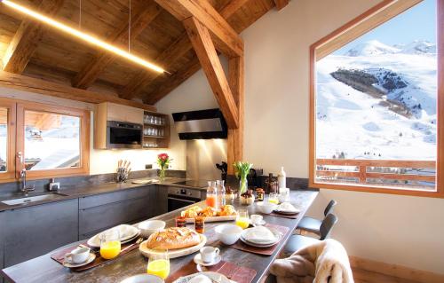 une cuisine avec une table avec de la nourriture dessus dans l'établissement Odalys Chalet Chambertin Lodge, à Les Deux Alpes
