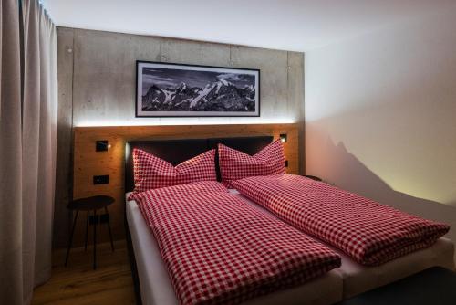 Una cama con almohadas rojas y blancas a cuadros. en Chalet Raufthubel en Mürren